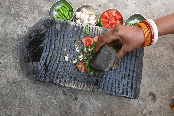 grinding-coriander-chutney-on-stone-600nw-2594469473.webp